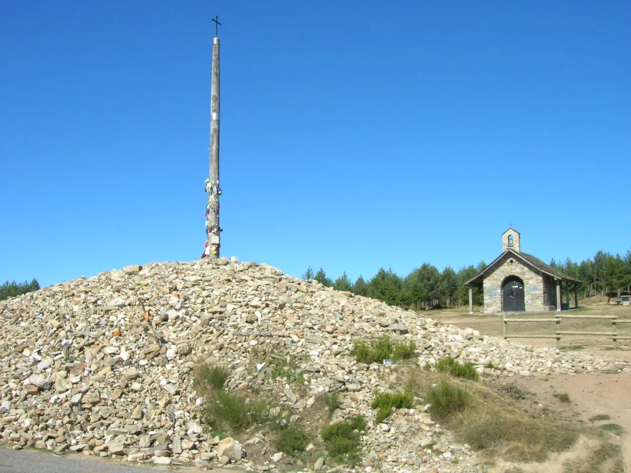 De kruis van Cruz de Ferro op de route naar Santiago de Compostella; daaronder de stapel stenen achtergelaten door de pelgrims.